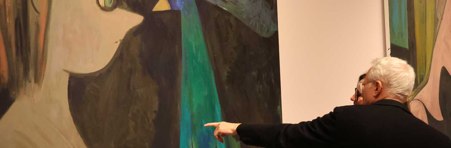 a man pointing at an abstract painting
