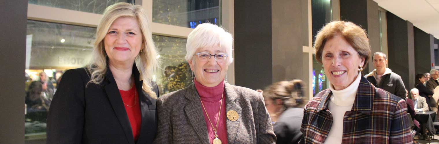 three ladies smiling at the camera at an event