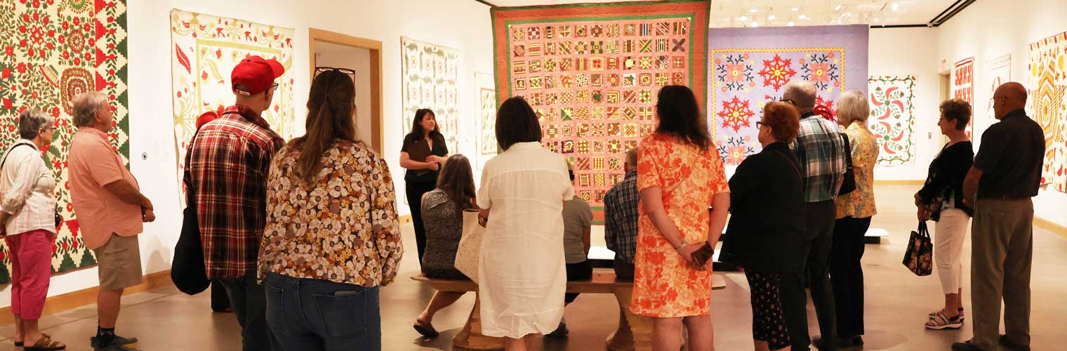 visitors looking at quilts
