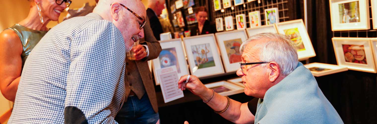 two men talking at a book signing